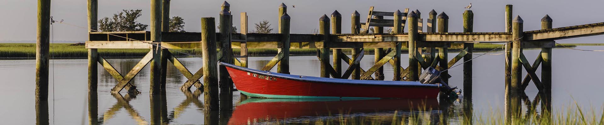 Photo of a red skiff tied to a dock
